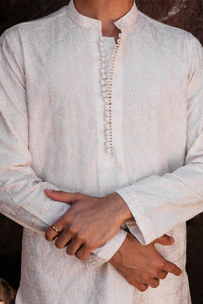 Close-up of the embroidery on the ivory white kurta pajama, focusing on the delicate patterns.